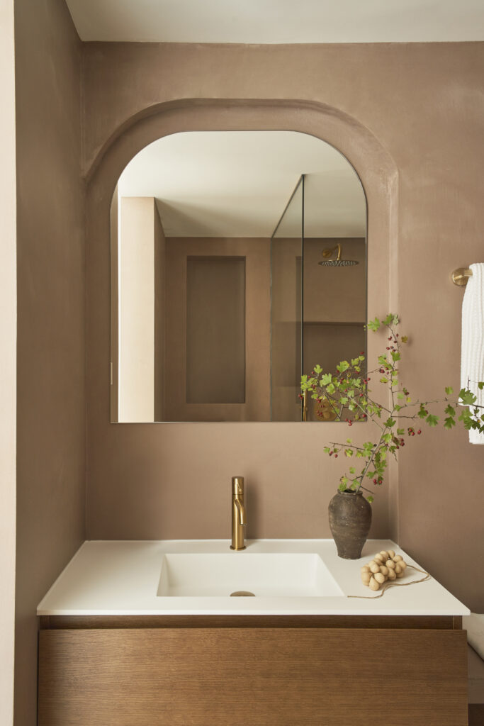Baño con microcemento en tonos cálidos con maderas naturales