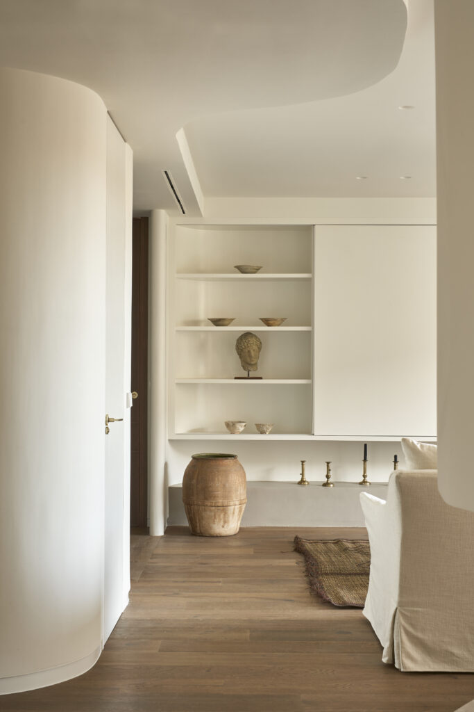 Paredes curvas en microcemento, suelo madera roble, jarrones decorativos