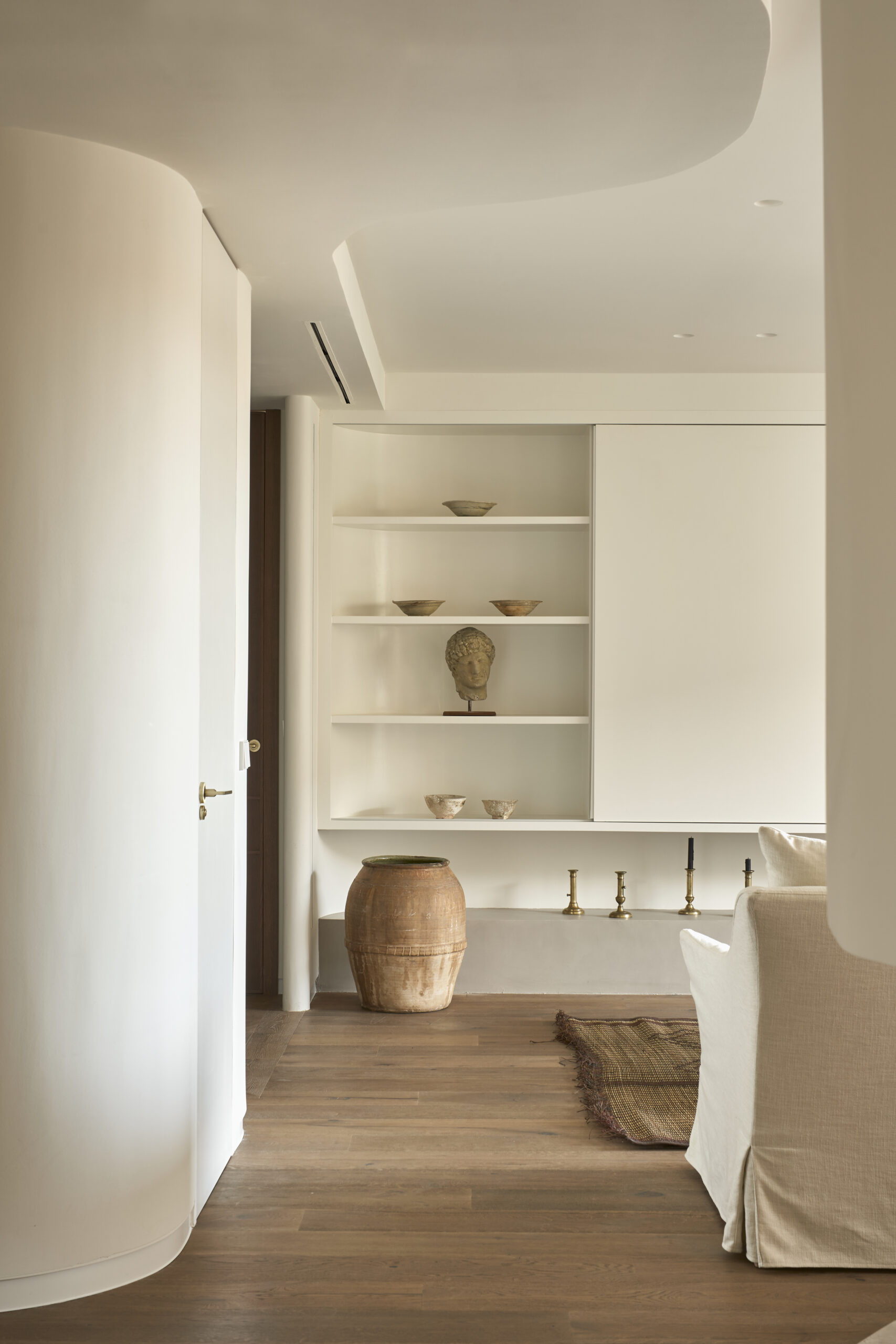 Paredes curvas en microcemento, suelo madera roble, jarrones decorativos